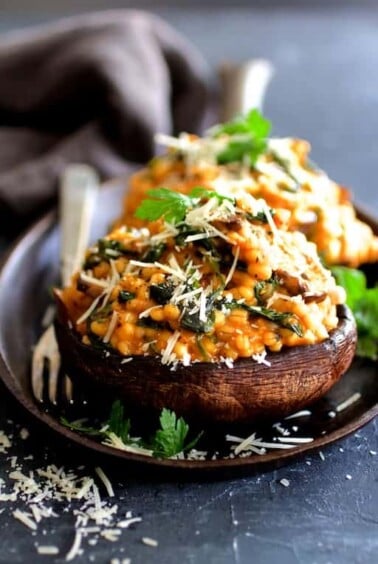 Two Barley Risotto Stuffed Portobello Mushrooms on small cast iron skillet.