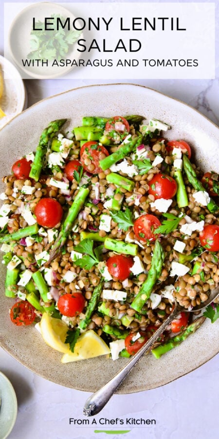 Pinterest graphic for Lemony Lentil Salad with Asparagus and Tomatoes showing it in an earthenware bowl with serving spoon.