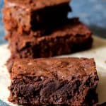 Three Whole Wheat Ancho Chili Brownies on a square of brown paper.