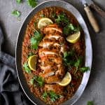 Slow Cooker Moroccan Turkey and Lentils on oval gray-rimmed platter garnished with lemon wedges.