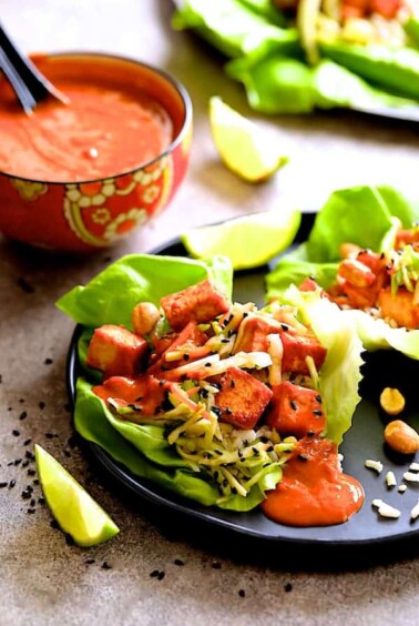 Vegan Korean Tofu Lettuce Wraps with Tahini Gochujang Sauce and Spicy Slaw - Hero shot of dish on black plate