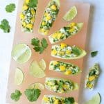 Crab Mango and Avocado Salad with Chile Lime Dressing in Endive - Overhead hero shot on pink salt block