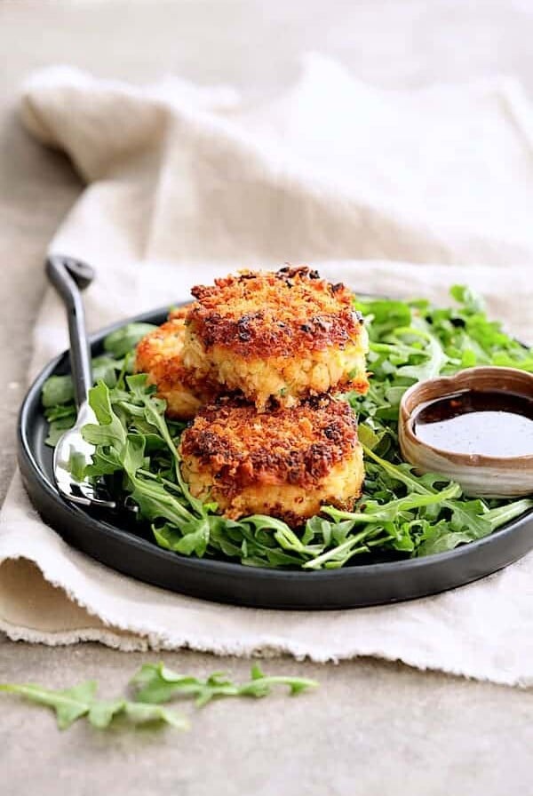 Tuna Kimchi Cakes with Soy Ginger Dipping Sauce - On plate over baby arugula