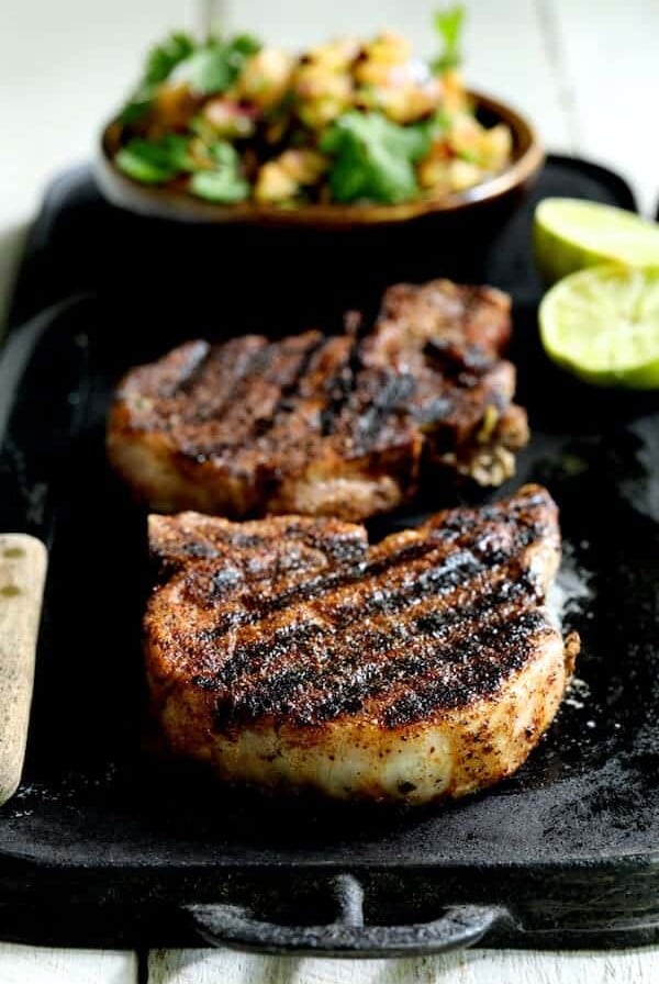 Southwestern Spiced Grilled Pork Chops with Plum Jalapeno Salsa showing it on an iron griddle.