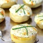 Goat Cheese Stuffed Artichoke Bottoms on silver platter garnished with chives.