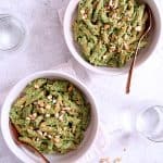 Two servings of Creamy Cashew and Spinach Pesto Sauce in white pasta bowls.