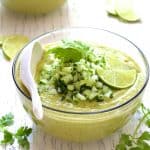 Cold Thai Cucumber Avocado Soup with Cucumber Relish in glass bowl.