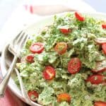 Chicken Pasta Salad with Spinach Buttermilk Dressing in white serving bowl with serving utensils.
