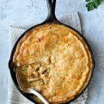 Cheesy Skillet Chicken Pot Pie with a piece removed showing the filling.