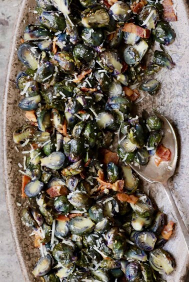 Roasted Purple Brussels Sprouts with Bacon and Parmesan - Overhead hero shot on brown platter