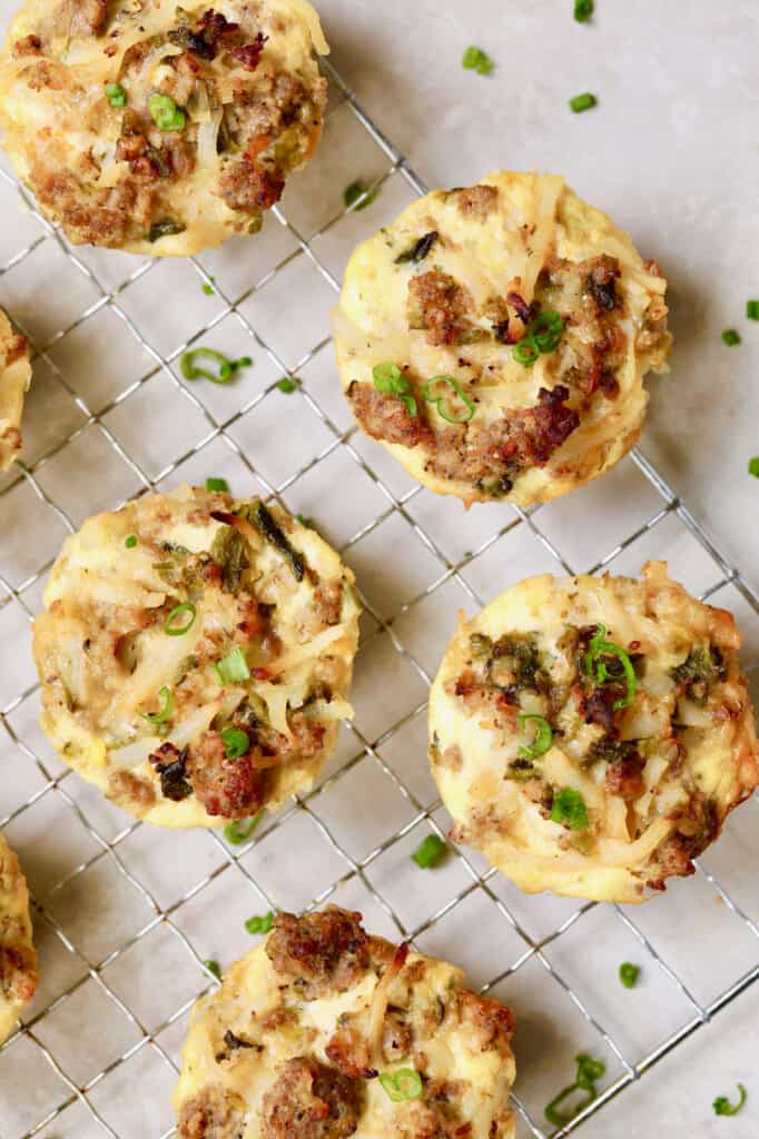 Photo of Hash Brown Breakfast Muffins with Poblano Peppers and Gouda Cheese on cooling rack garnished with chives.