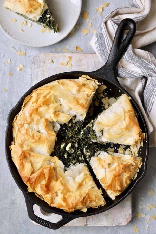 Skillet Spanakopita (Greek Spinach and Feta Pie) - Overhead shot in cast iron skillet with gray striped towel