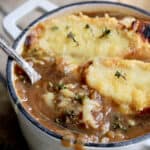 French Onion Soup for Two - Close-up shot with spoon lifting out some of the soup