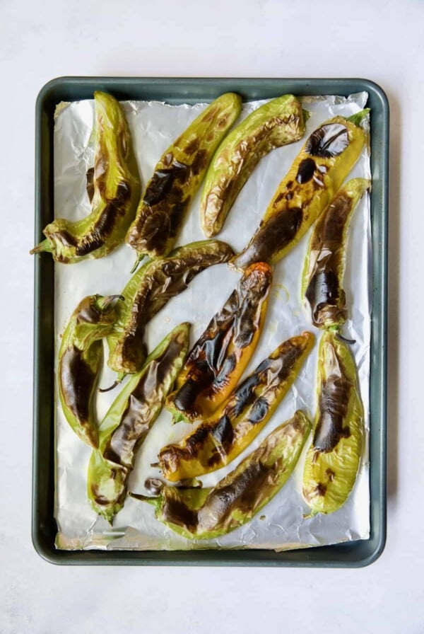 Fully roasted Hatch green chiles on rimmed sheet pan.