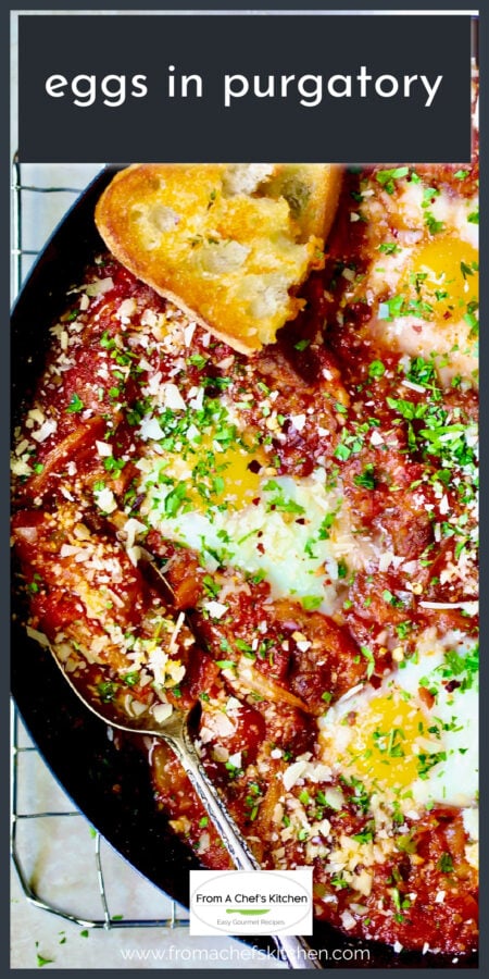 Eggs in Purgatory in black cast iron skillet with spoon and toast.