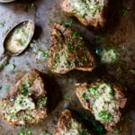 Seared Lamb Chops with Anchovy Butter on patinated baking sheet.