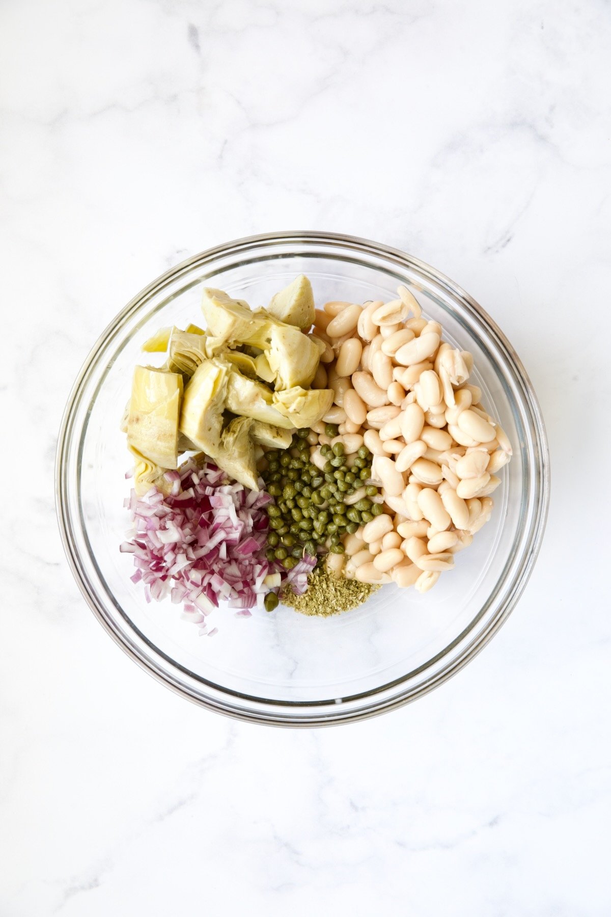 Ingredients for tuna salad in glass bowl before being combined.