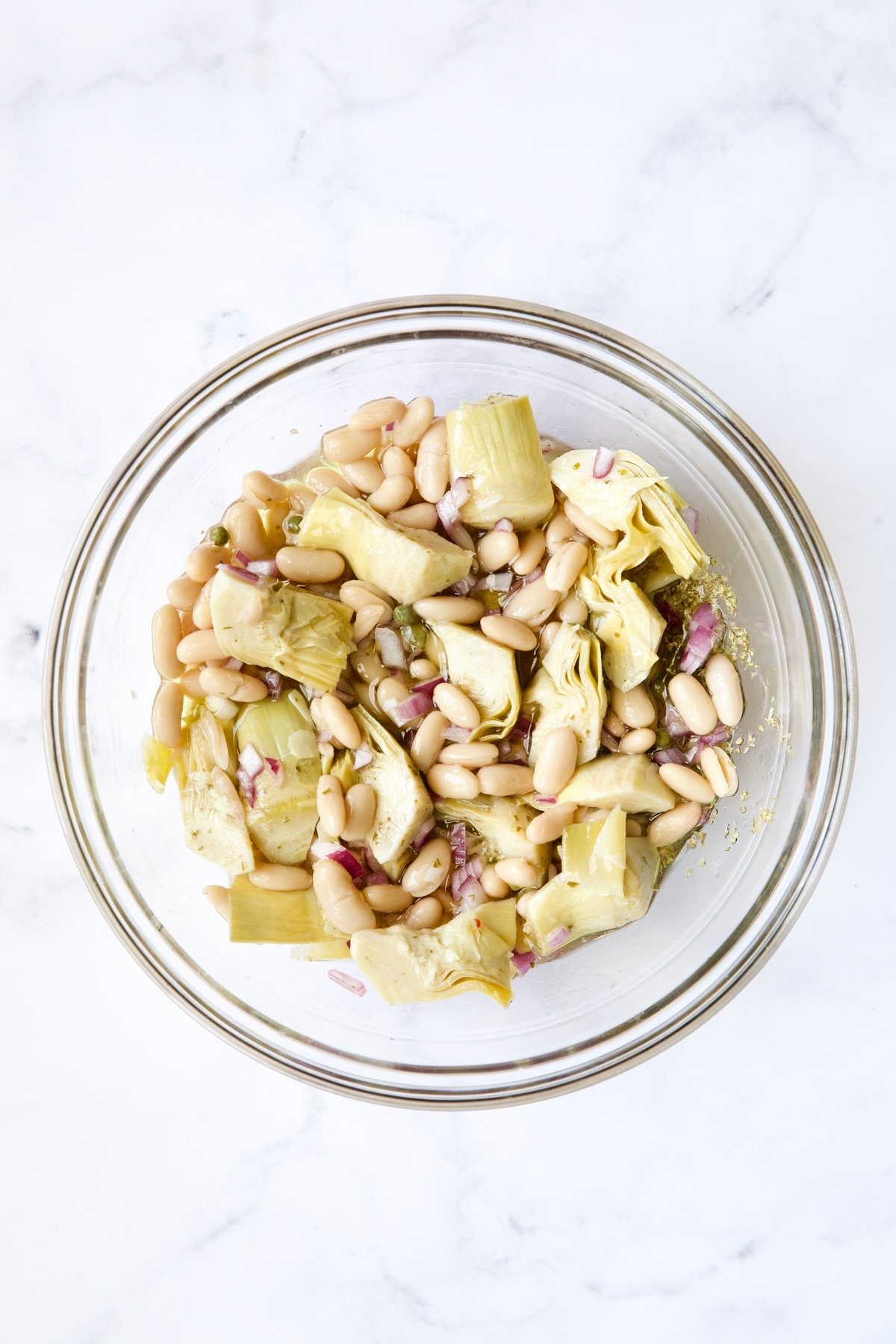 Artichokes and beans in glass bowl.