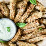 Air Fryer Eggplant Fries with Garlic Basil Aioli garnished with fresh basil.
