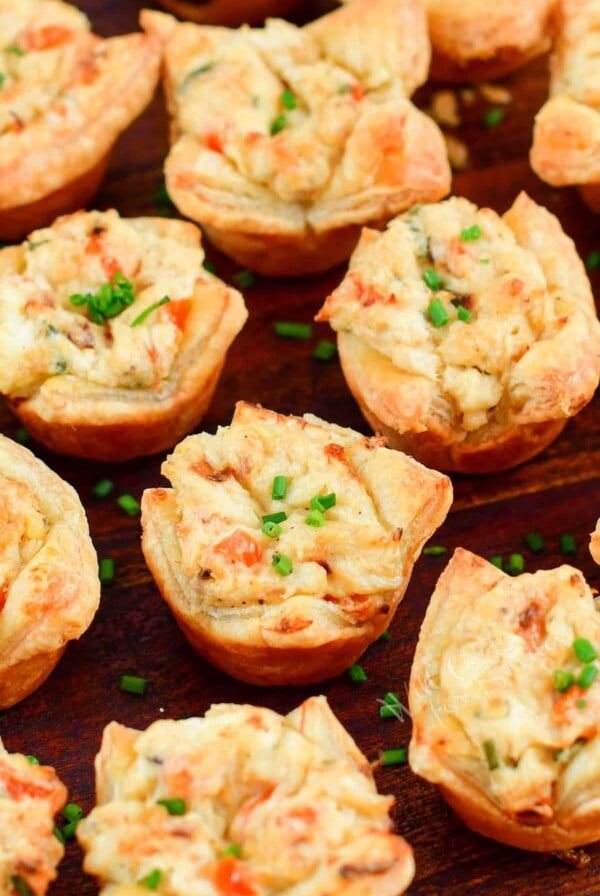 Crab Puffs on wood surface garnished with chopped chives.