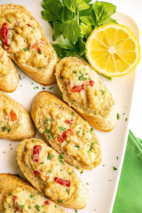 Crab Melts Appetizer on white platter garnished with parsley and lemon.