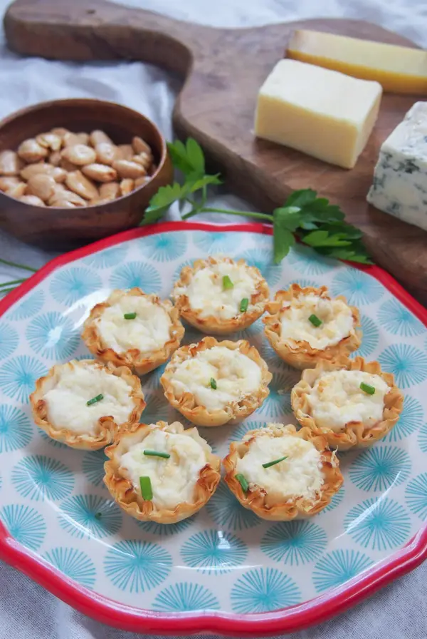 Eight Crab-Stuffed Phyllo Cups on blue plate with red rim.