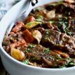 Short Ribs Bourguignon in white oval serving dish with meat fork.