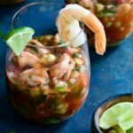 Mexican Shrimp Cocktail in glass garnished with lime wedge and shrimp.