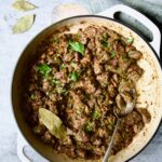 Beef Tips in Beer Sauce in white enamel cast iron skillet.