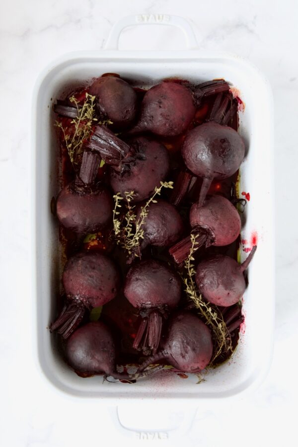 Roasted beets in white rectangular roasting dish.