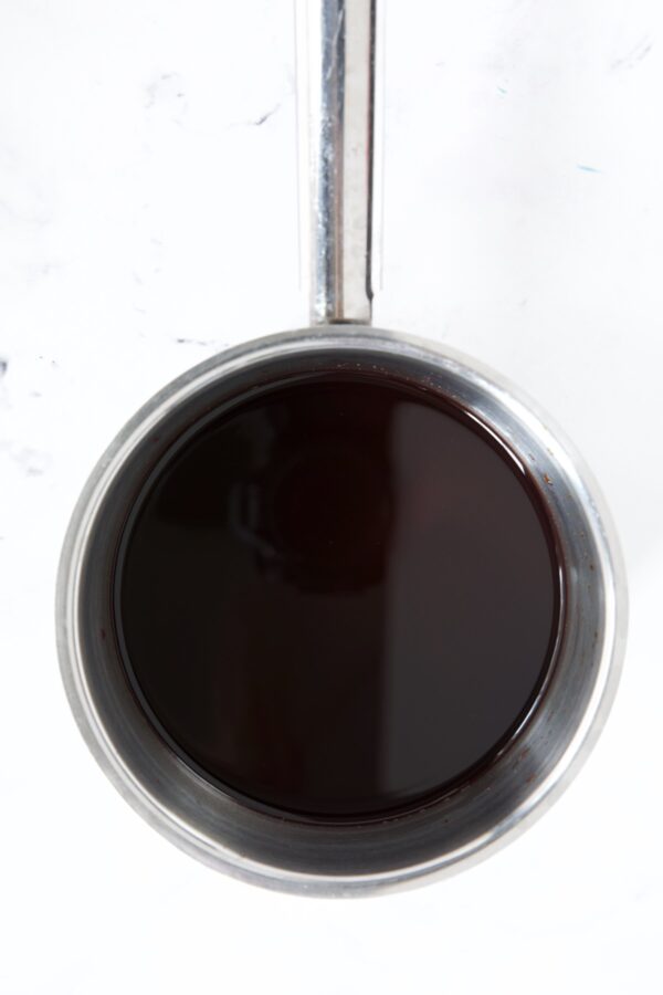 Red wine glaze in stainless steel saucepan.