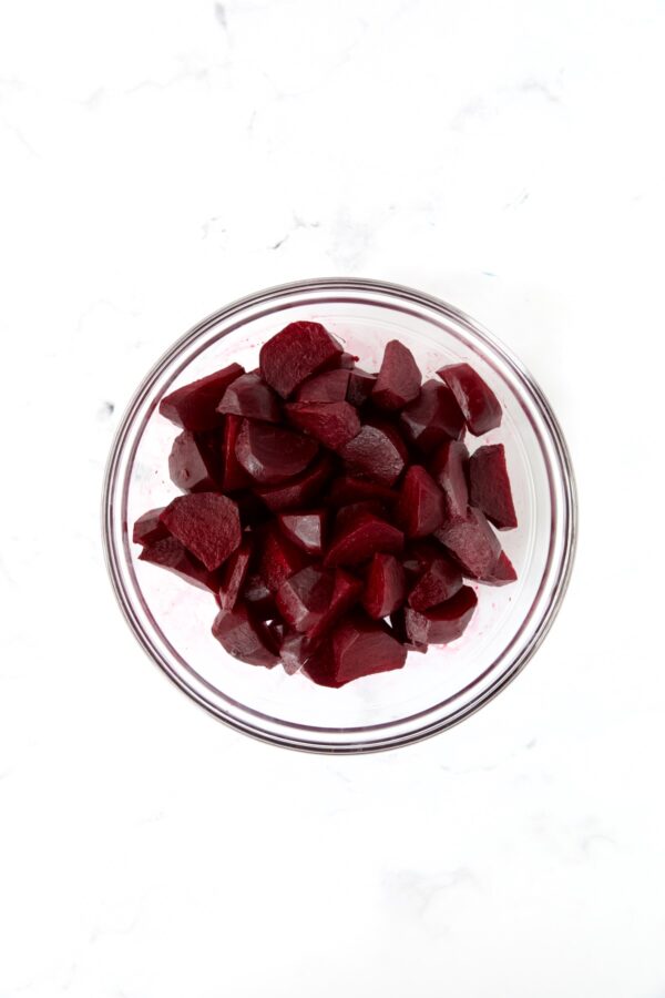 Roasted beets cut into wedges in glass bowl.