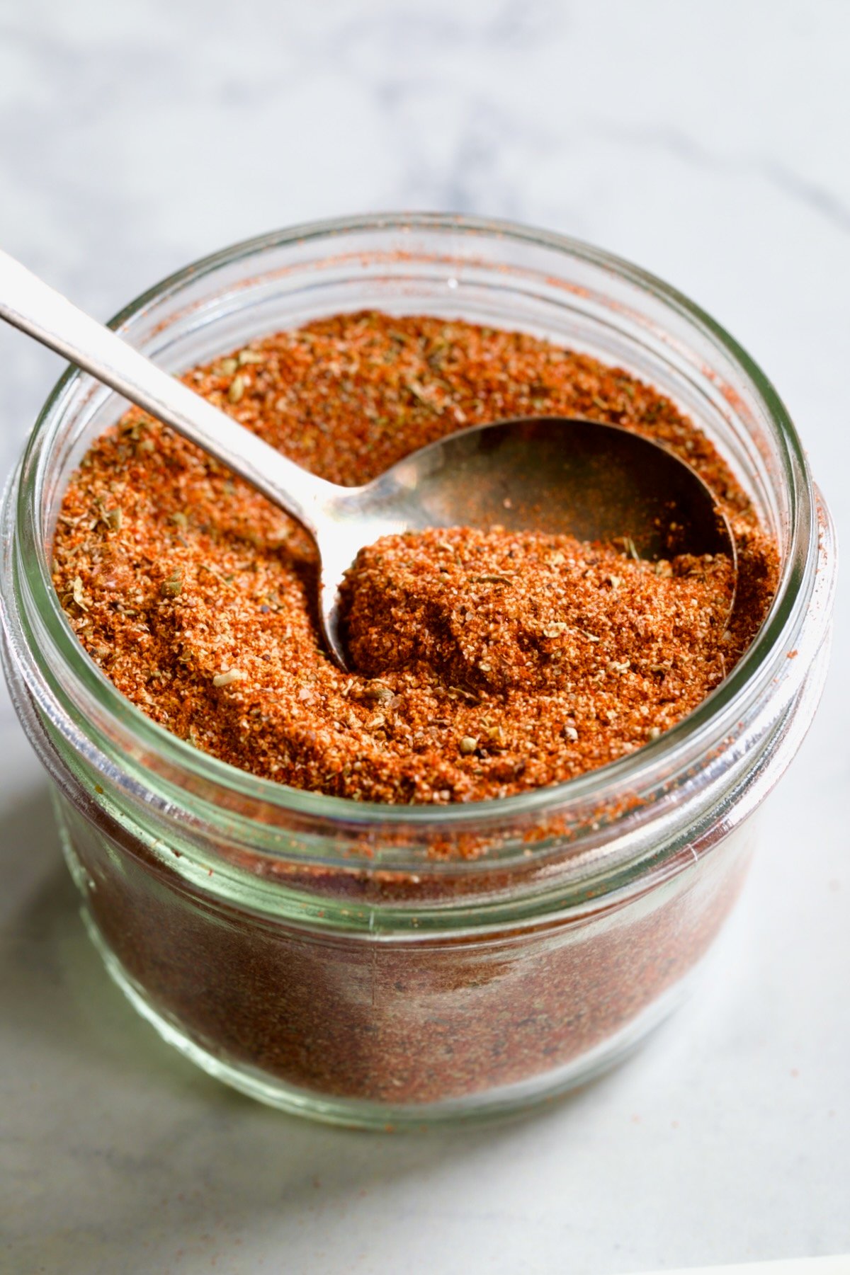 Jar of Blackening Seasoning with spoon scooping some out.