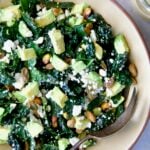 Tuscan Kale Salad with Lemon Tahini Dressing in beige bowl with serving spoon.
