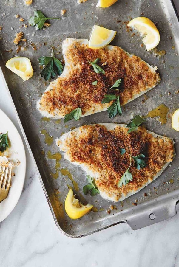 Two pieces of Lemon Sole Oreganato on sheet pan.