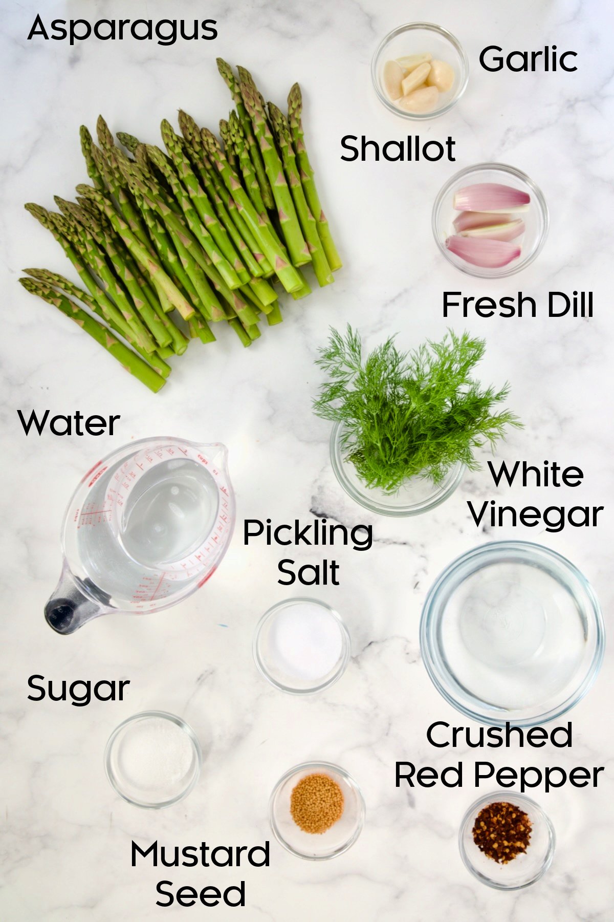 Ingredients for Pickled Asparagus in glass bowls.