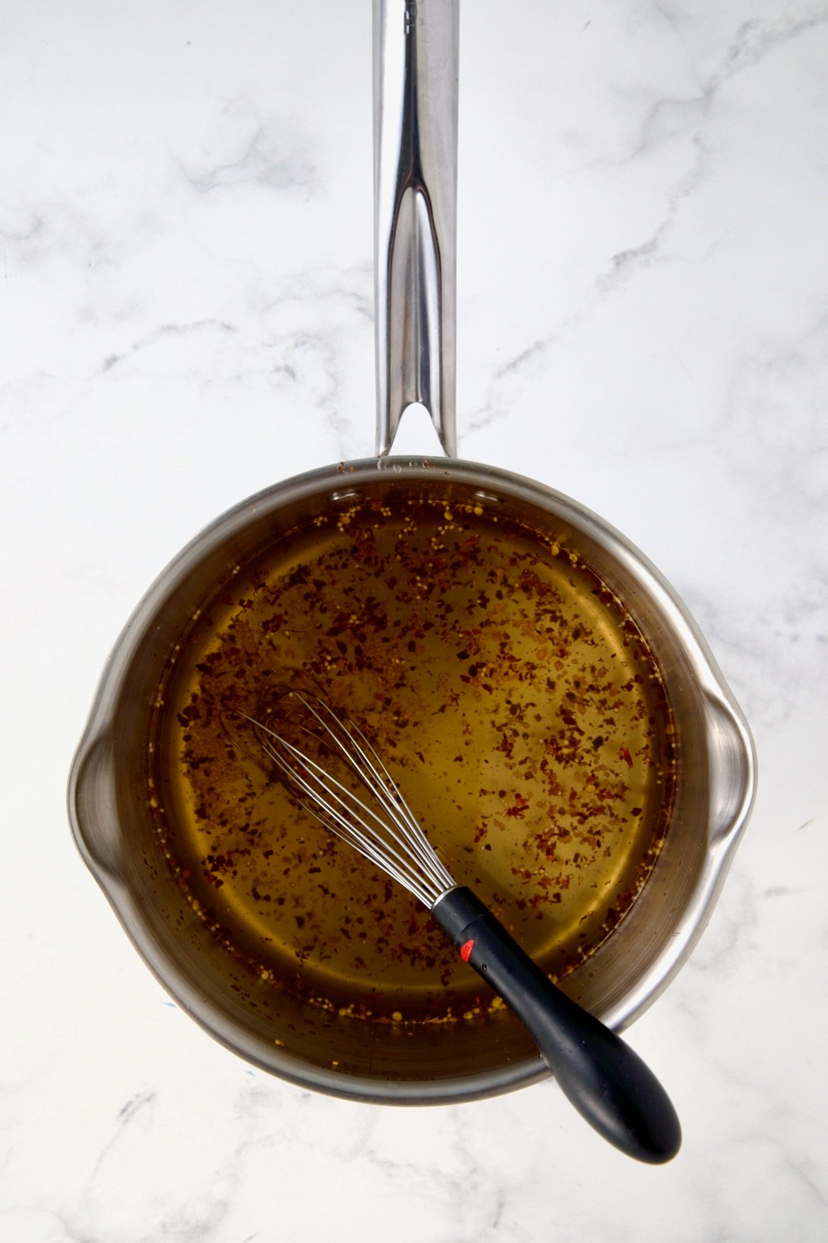 Brine in stainless steel saucepan with whisk.