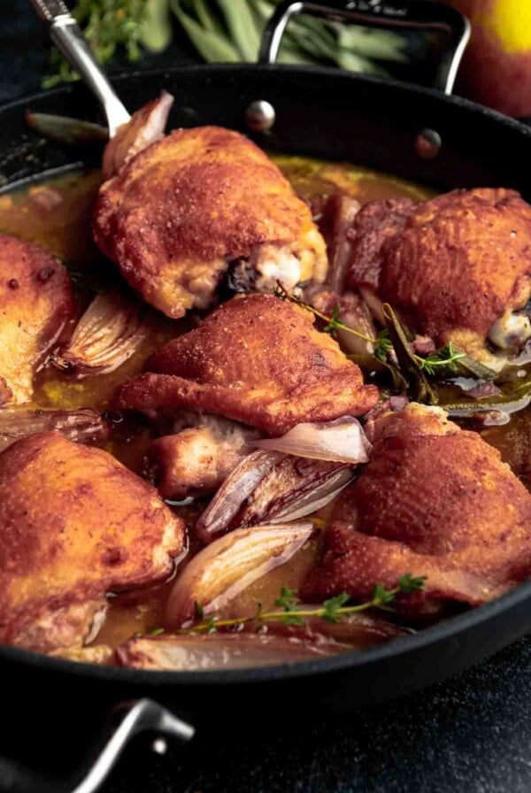 Six Cider-Braised Chicken Thighs in cast iron skillet.