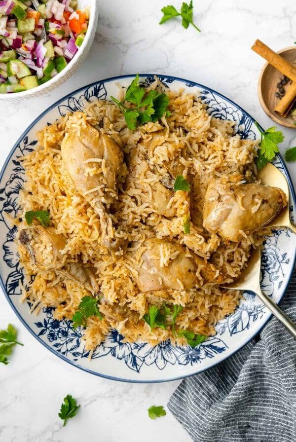 Four chicken thighs with rice on round platter.