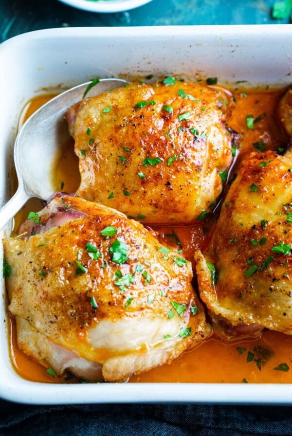 Three Oven-Baked Chicken Thighs in white baking dish.