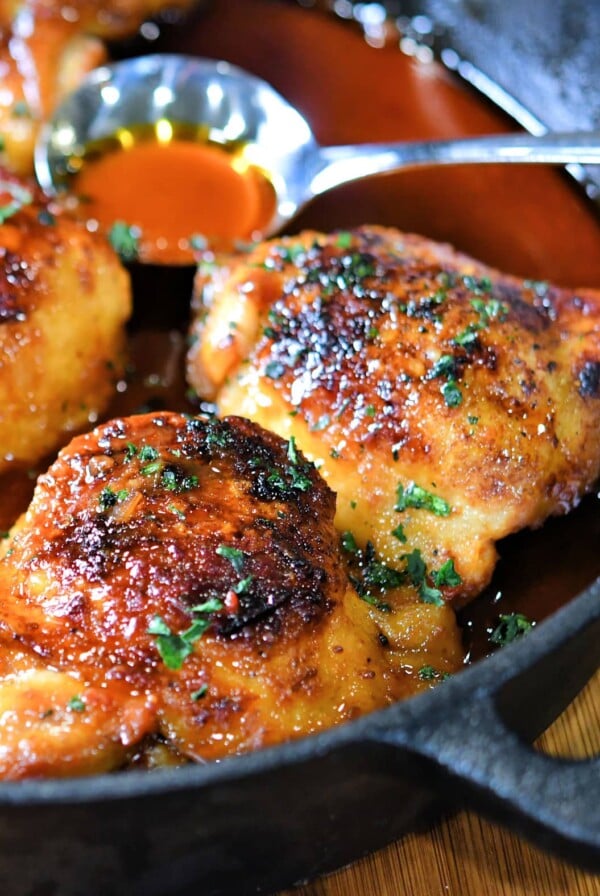 Three Sweet and Spicy Chicken Thighs in cast iron skillet.