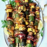 Grilled Vegetable Kabobs on oval white platter garnished with parsley and lemon slices.