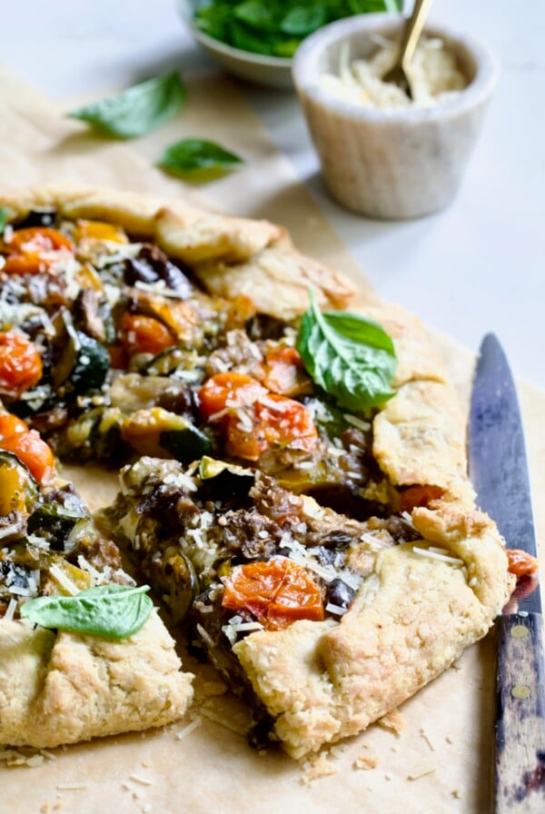 Two wedges of Mediterranean Vegetable Galette on parchment paper.