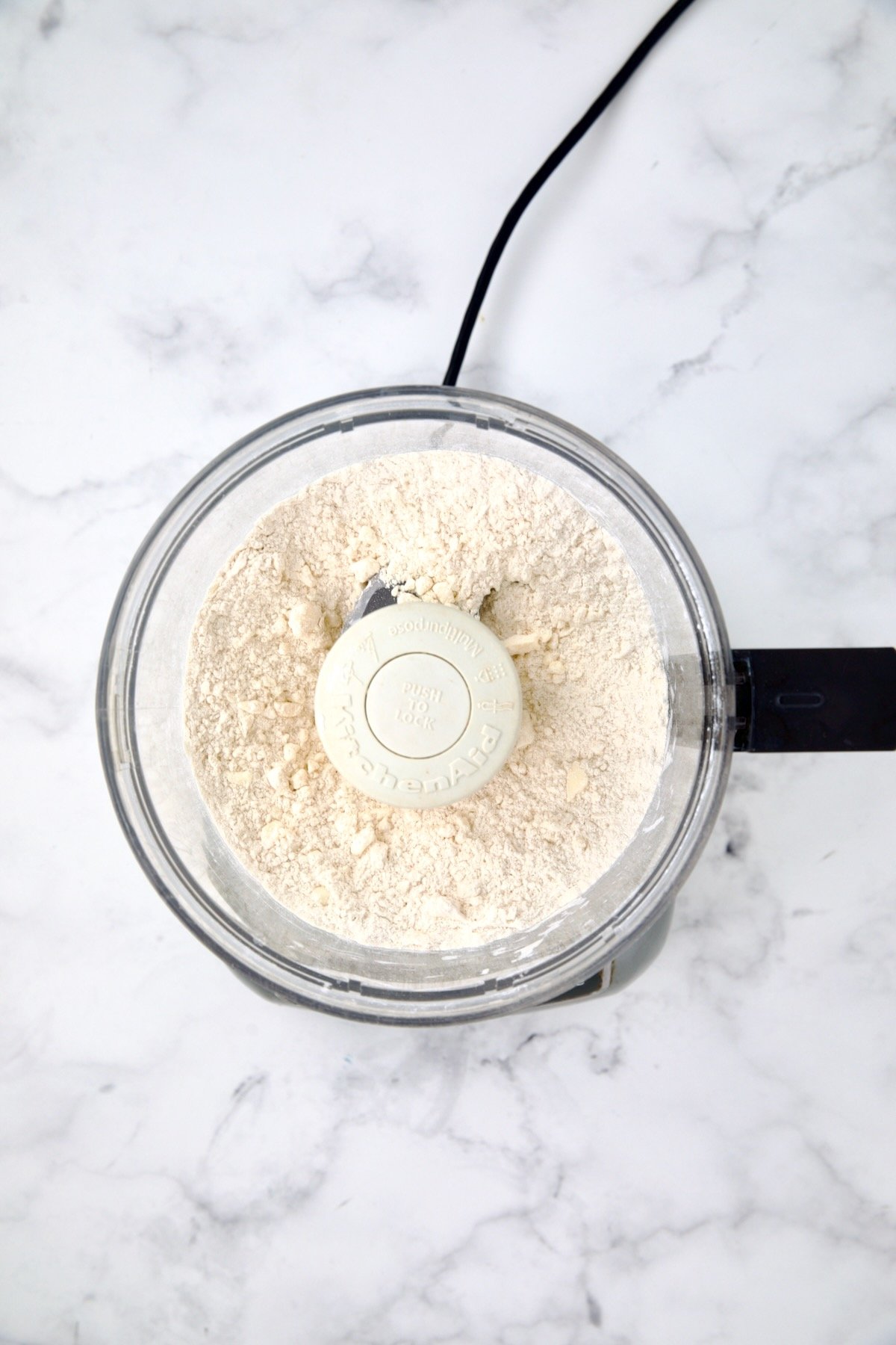 Ingredients for galette dough in food processor after being combined.