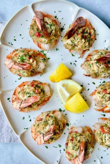 Crab-Stuffed Shrimp on oval white platter garnished with parsley and lemon wedges.