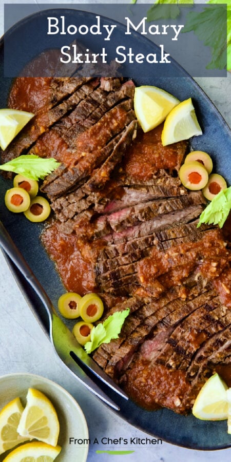 Pinterest graphic for Bloody Mary Skirt Steak showing it on a blue platter garnished with lemon wedges, celery leaves and sliced green olives.