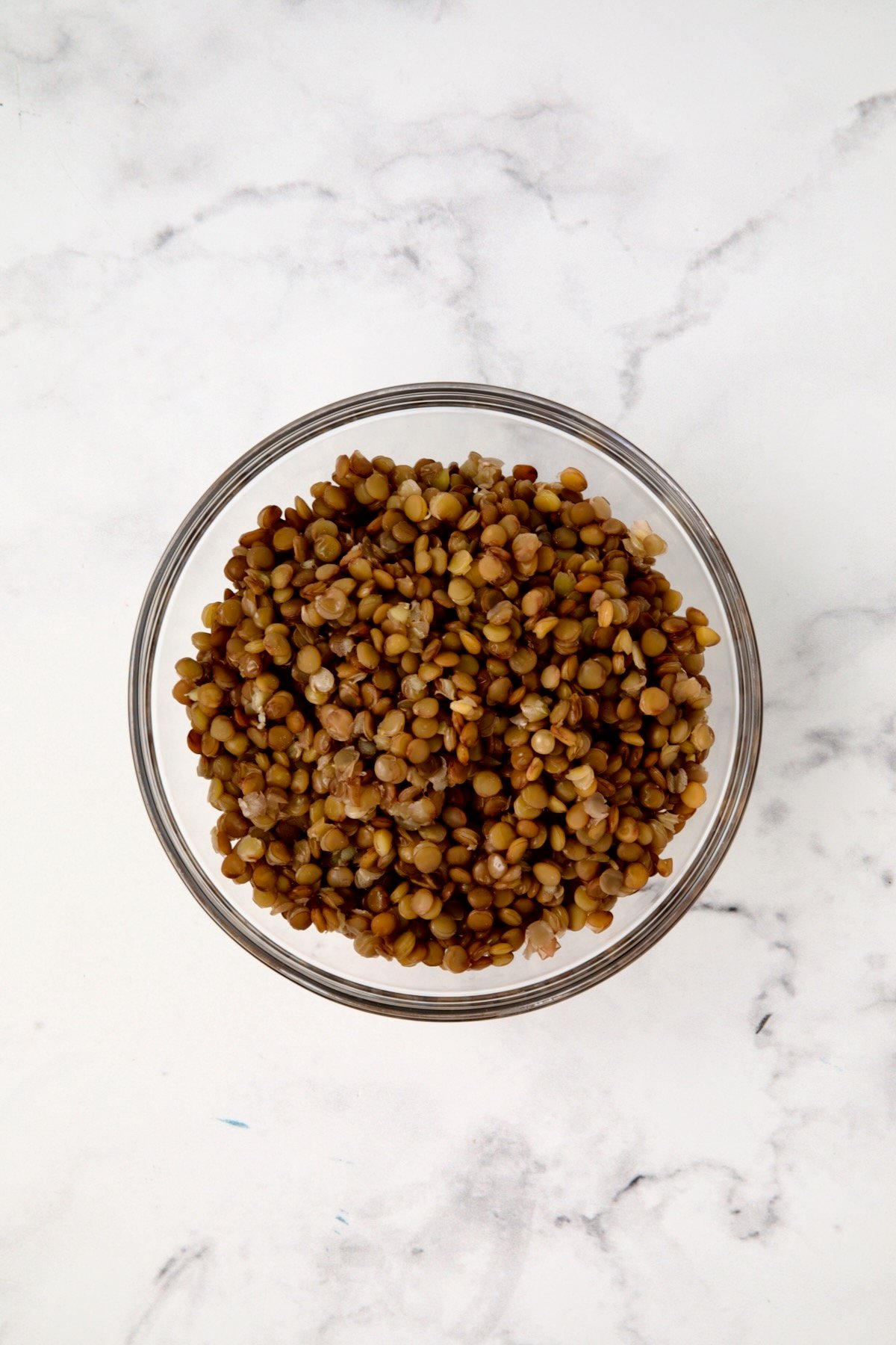 Cooked lentils in glass bowl.