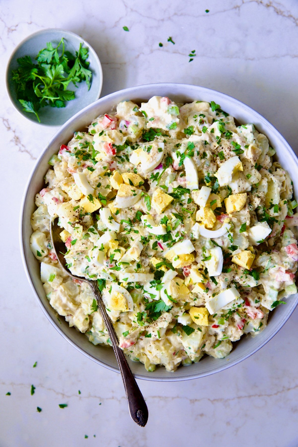 Potato Salad with Horseradish Dressing in light blue bowl with serving spoon.