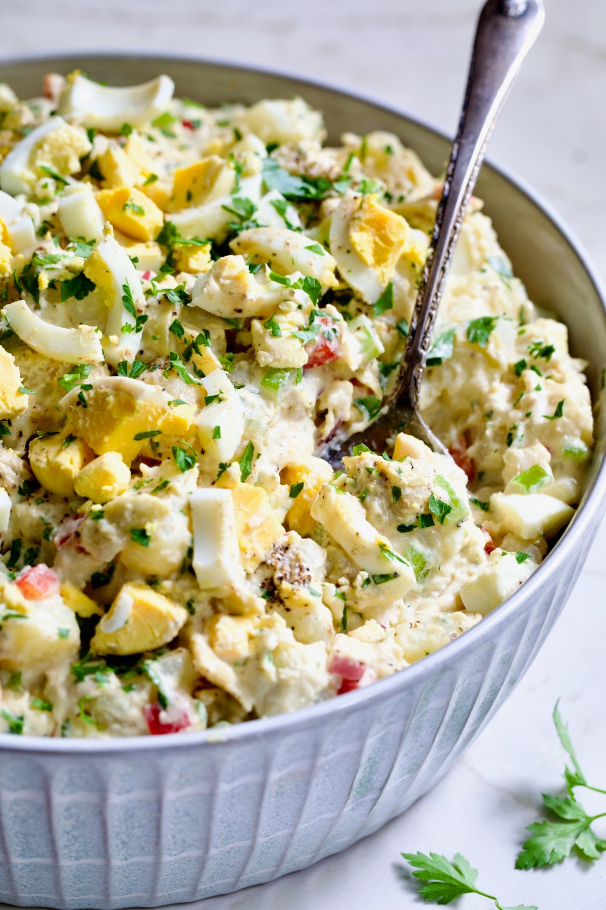 Potato Salad with Horseradish Dressing in light blue bowl with serving spoon.