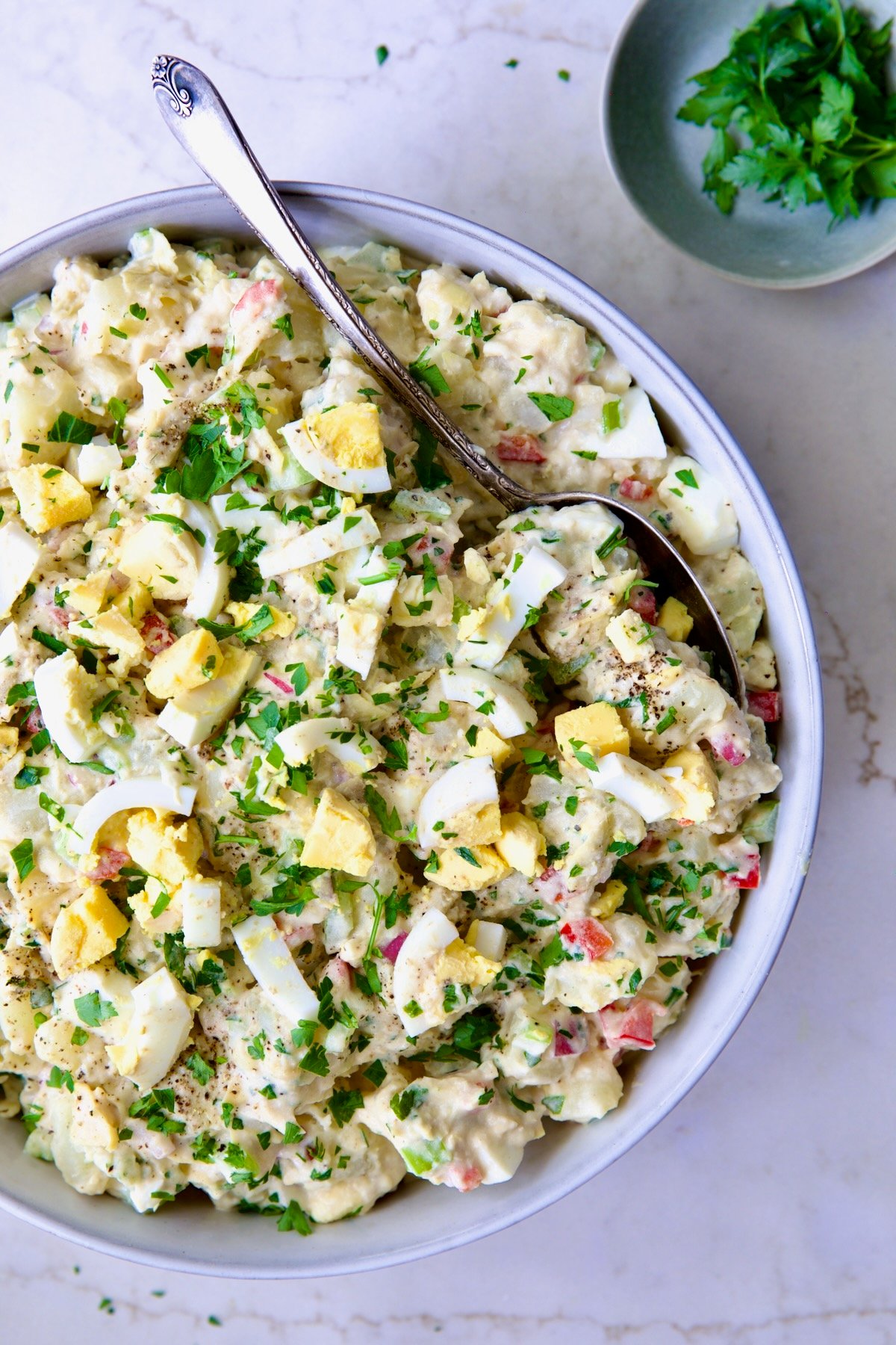 Potato Salad with Horseradish Dressing in light blue bowl with serving spoon.